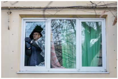 A resident removes broken glass from his window damaged by a Russian missile strike in Selydove, in Ukraine’s Donetsk region (Reuters)